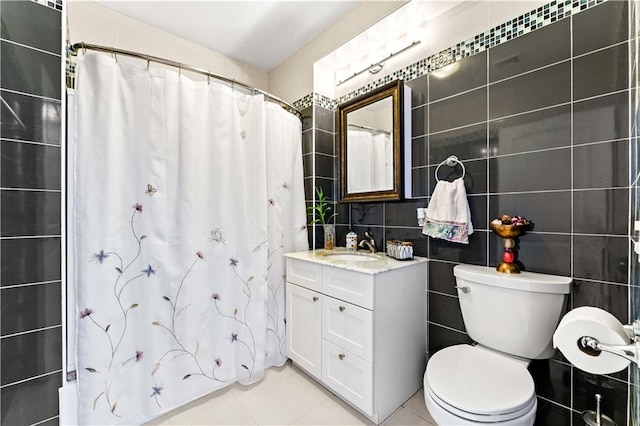 bathroom with tile patterned flooring, vanity, tile walls, and walk in shower