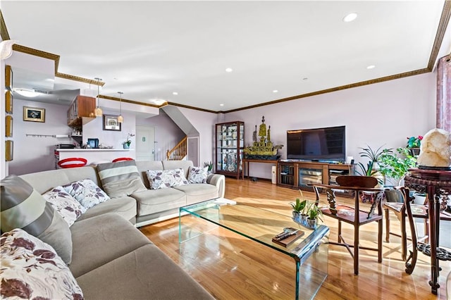 living room with light hardwood / wood-style floors and crown molding