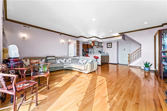 living room with hardwood / wood-style floors and crown molding