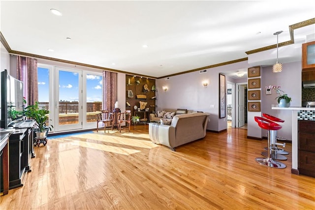 living room featuring hardwood / wood-style floors and crown molding