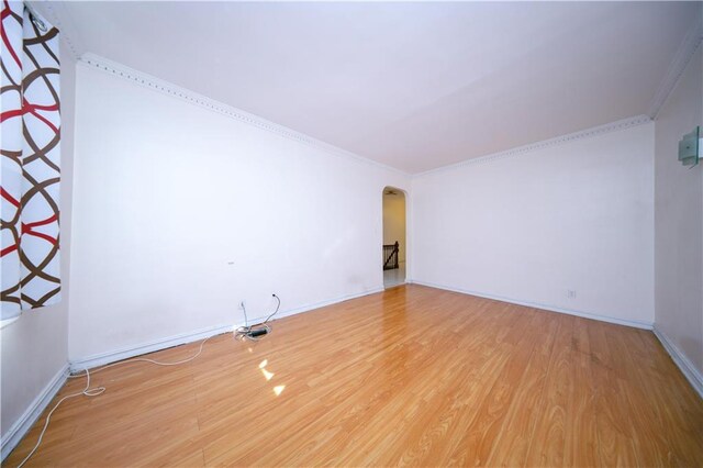 unfurnished room with ornamental molding and hardwood / wood-style floors