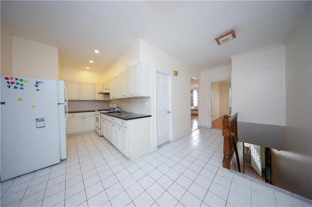 kitchen featuring tasteful backsplash, light tile patterned floors, white appliances, and white cabinets