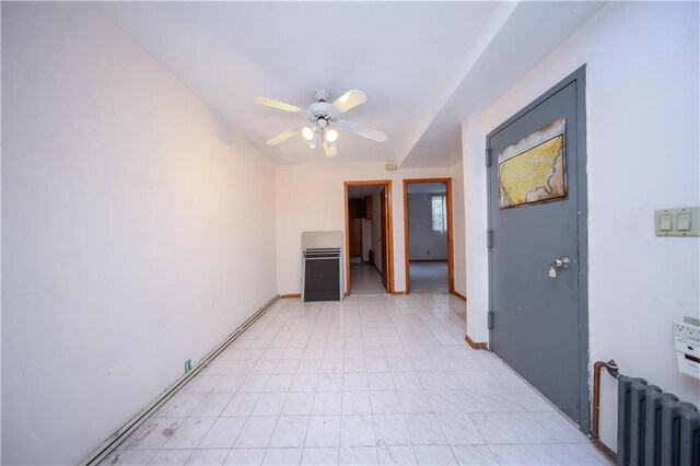 empty room featuring radiator heating unit and ceiling fan