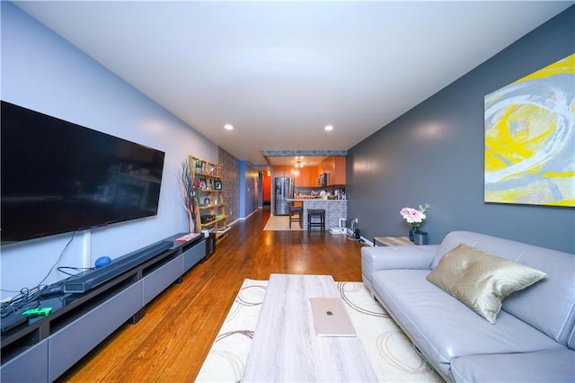 living room featuring recessed lighting, a fireplace, and wood finished floors