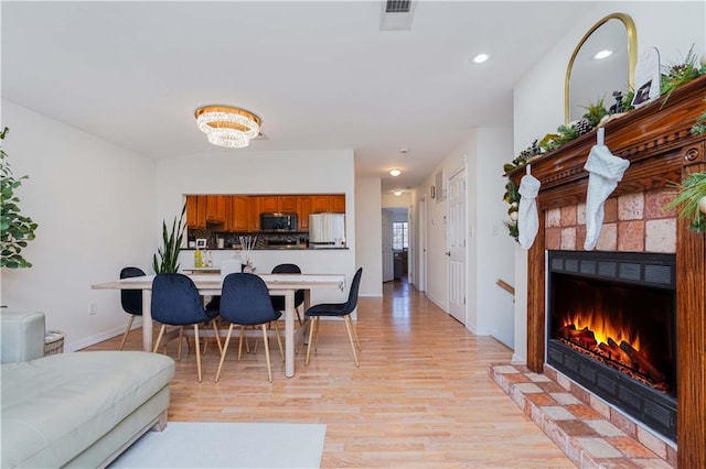 living room with light hardwood / wood-style floors and a tile fireplace