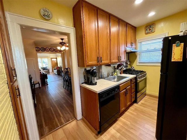 kitchen featuring ceiling fan, light hardwood / wood-style floors, sink, and black appliances