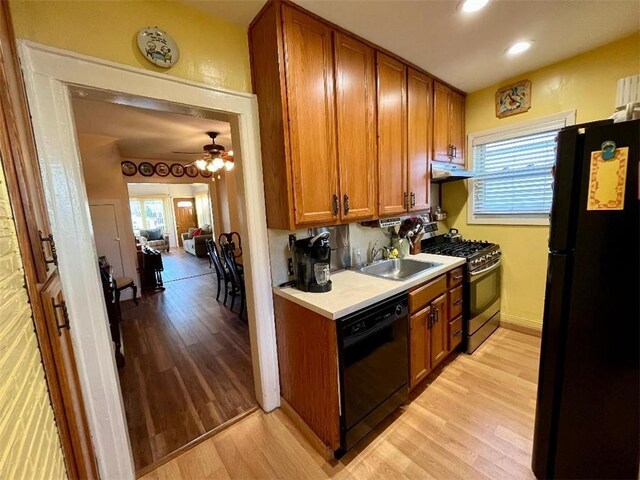 kitchen featuring sink, plenty of natural light, black appliances, and light hardwood / wood-style floors