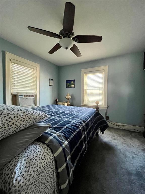 bedroom with carpet floors, ceiling fan, baseboards, and cooling unit