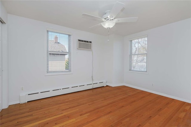 unfurnished room with plenty of natural light, wood-type flooring, a wall unit AC, and a baseboard radiator