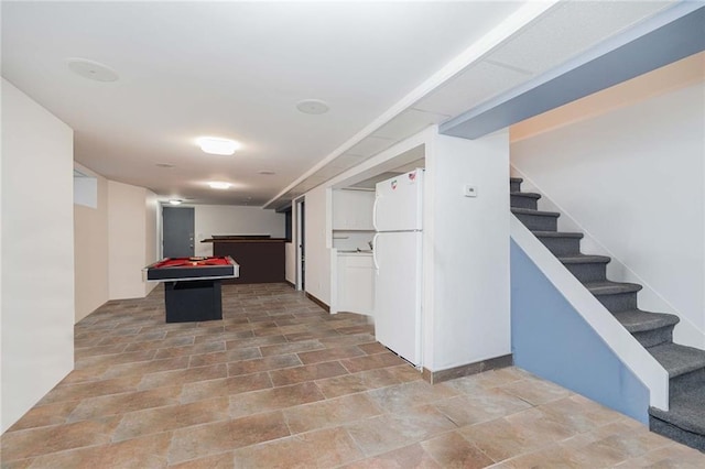 interior space with billiards, stairs, and freestanding refrigerator