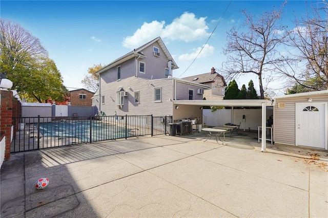 back of house featuring a fenced in pool, a patio, an outbuilding, fence, and a shed