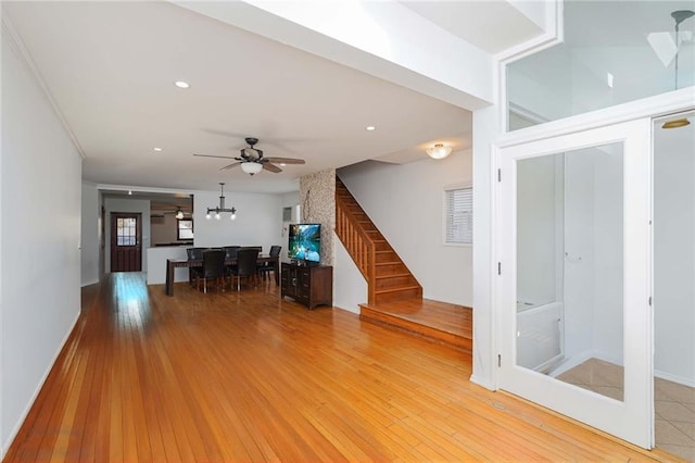 unfurnished living room featuring ceiling fan and light hardwood / wood-style flooring