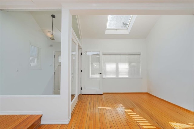 hall featuring light hardwood / wood-style flooring and lofted ceiling with skylight