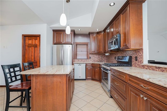 kitchen featuring backsplash, a breakfast bar, stainless steel appliances, a center island, and hanging light fixtures