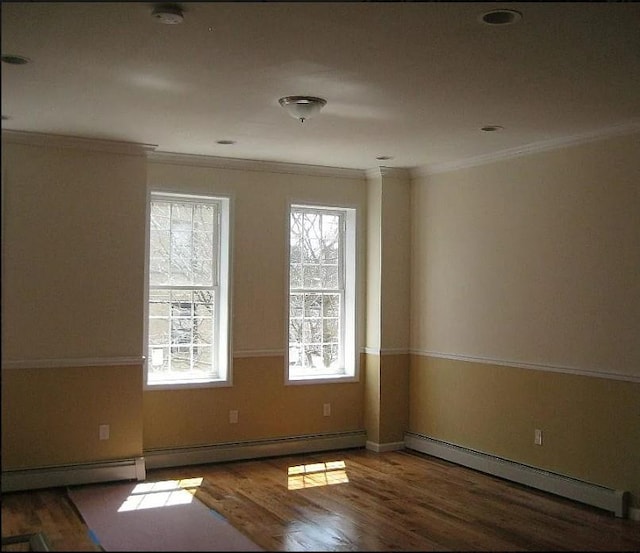 spare room featuring crown molding, a baseboard radiator, and dark hardwood / wood-style floors