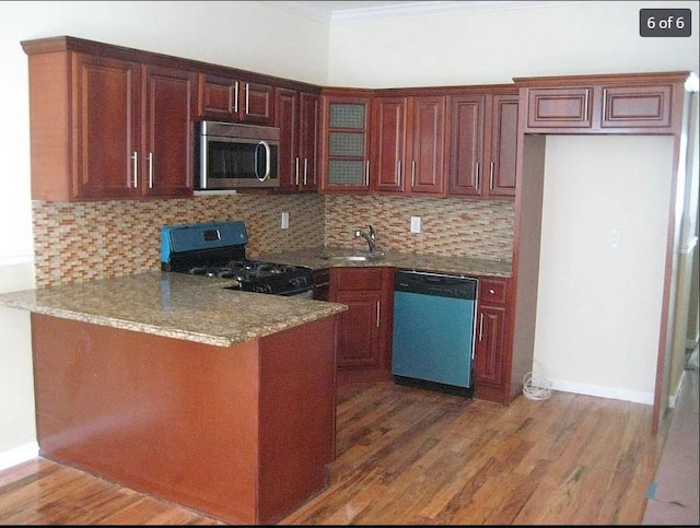 kitchen with sink, dark wood-type flooring, stainless steel appliances, and ornamental molding