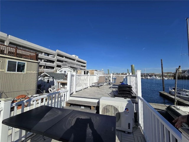 wooden terrace featuring a water view and ac unit