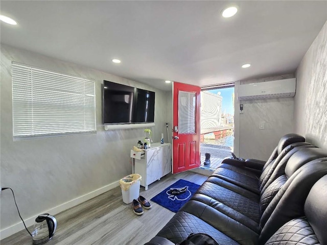 living room with hardwood / wood-style flooring and a wall unit AC