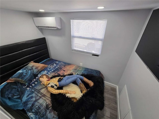 bedroom featuring a wall mounted AC, wood finished floors, and recessed lighting