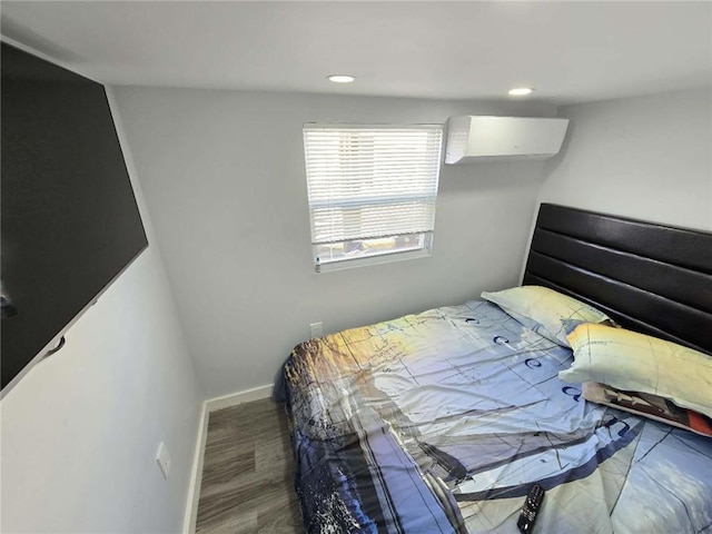 bedroom featuring wood-type flooring and a wall unit AC