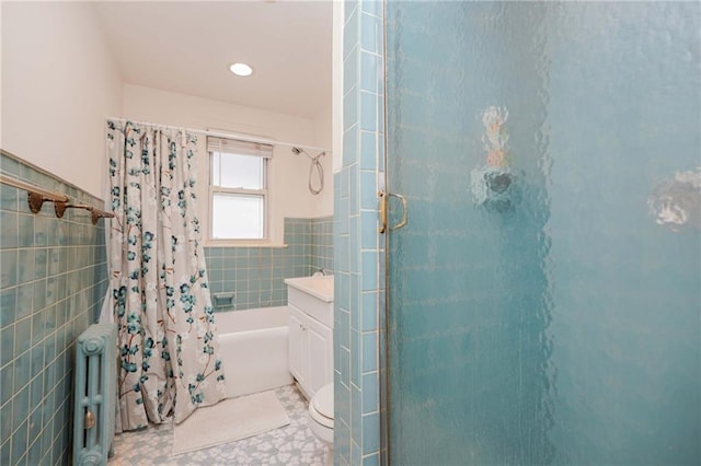bathroom featuring tile walls, radiator heating unit, shower / bath combination with curtain, vanity, and a wainscoted wall