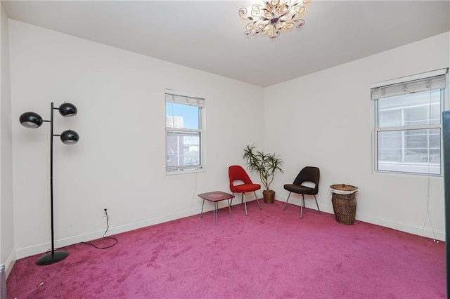 sitting room featuring carpet flooring, a chandelier, and baseboards