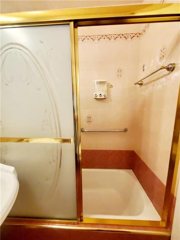 full bathroom featuring a shower with door and a sink