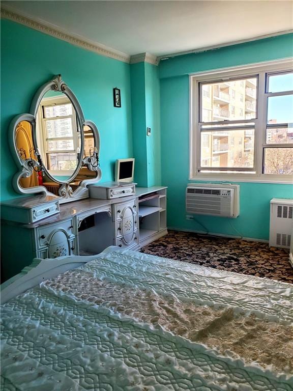 bedroom with radiator heating unit, crown molding, and a wall mounted AC