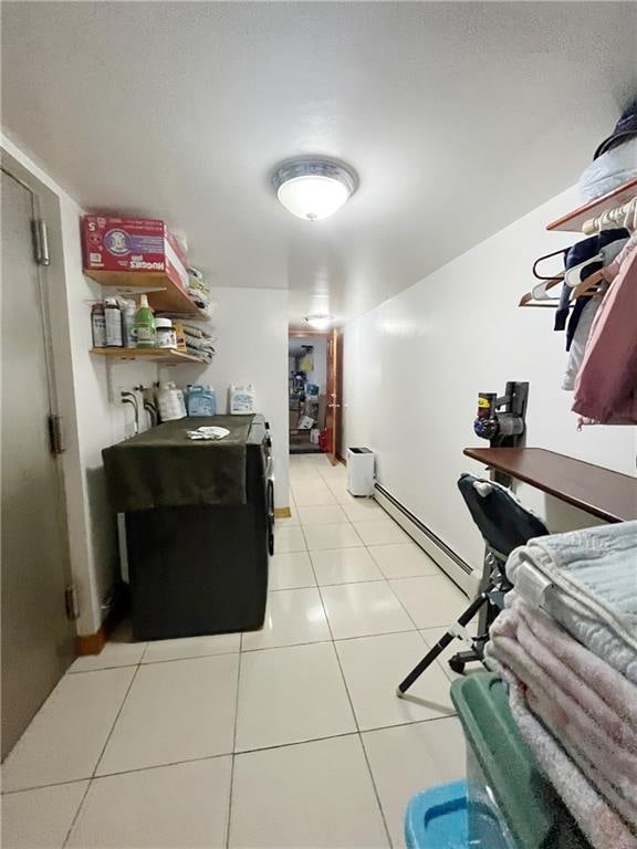 interior space with separate washer and dryer, light tile patterned floors, and a baseboard heating unit