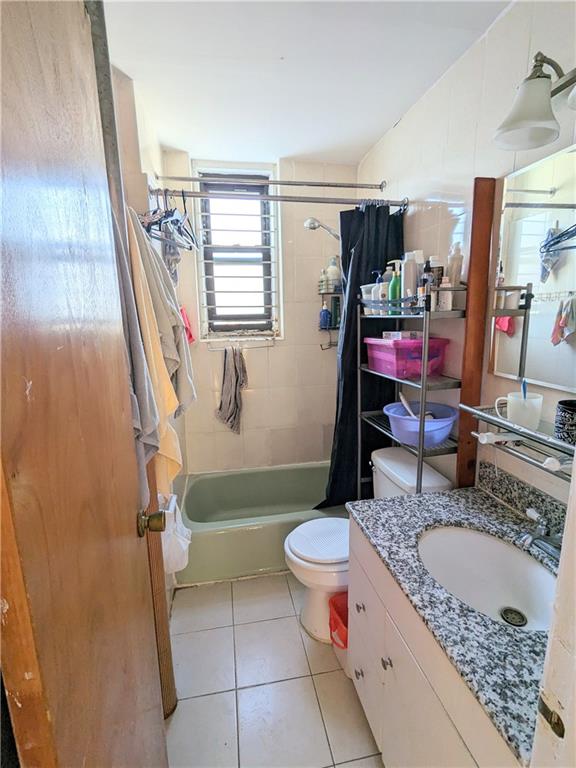 full bathroom featuring tile patterned floors, vanity, toilet, and shower / bath combo