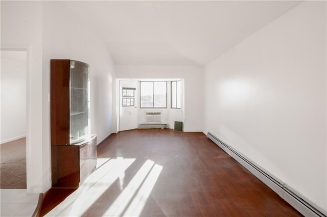 interior space with an AC wall unit, a baseboard heating unit, and vaulted ceiling