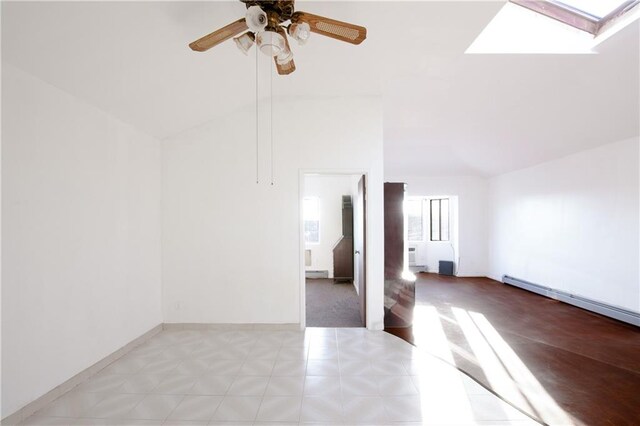 unfurnished room featuring lofted ceiling with skylight, ceiling fan, and a baseboard radiator