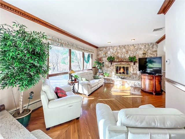 living room with a fireplace, wood finished floors, visible vents, and crown molding