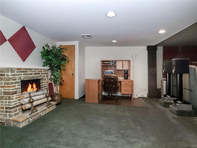 office with dark carpet, a lit fireplace, visible vents, and recessed lighting