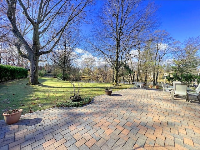 view of home's community featuring a patio area and a lawn