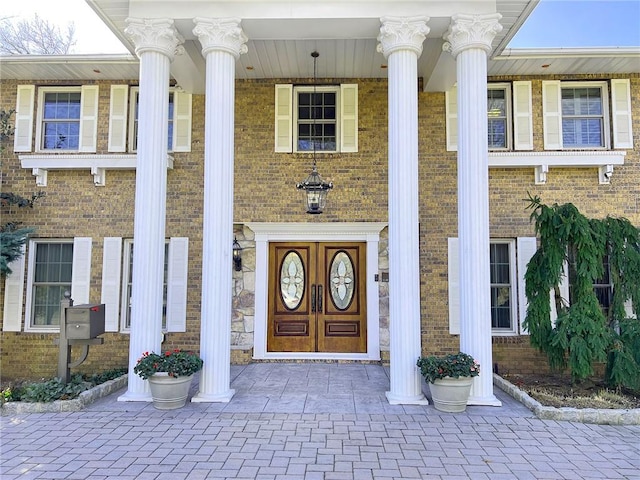 view of exterior entry with stone siding and brick siding