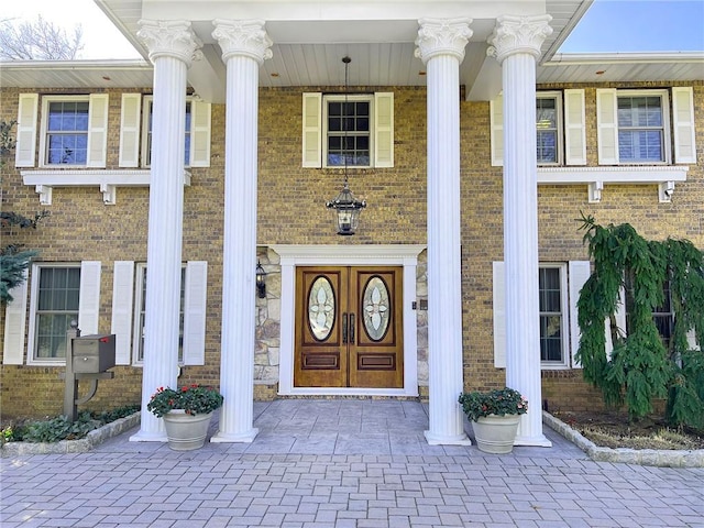 doorway to property with brick siding