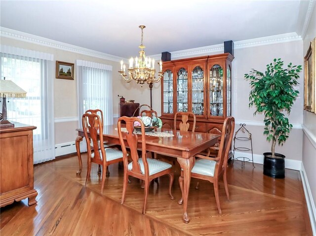 dining area featuring ornamental molding, an inviting chandelier, wood finished floors, and a baseboard heating unit