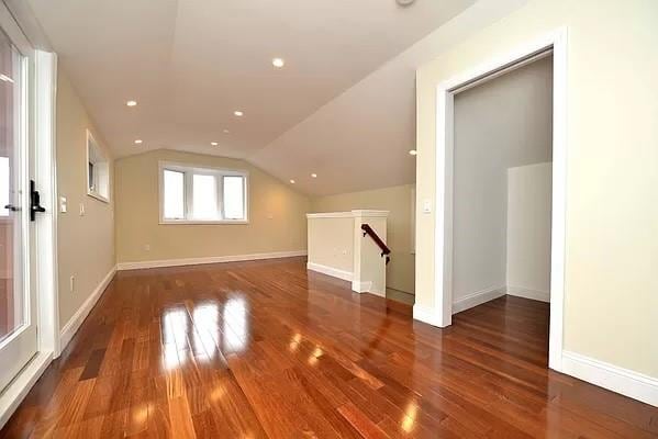 additional living space with vaulted ceiling and dark hardwood / wood-style floors