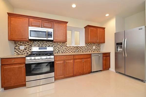 kitchen with stainless steel appliances, sink, and decorative backsplash