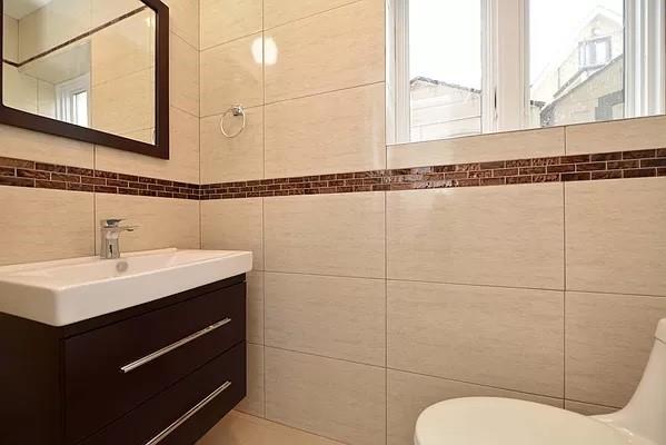 bathroom with vanity, toilet, and tile walls