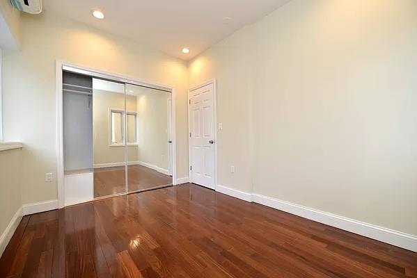 unfurnished bedroom featuring wood-type flooring and a closet