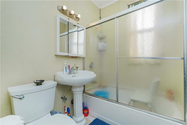 full bath with toilet and bath / shower combo with glass door