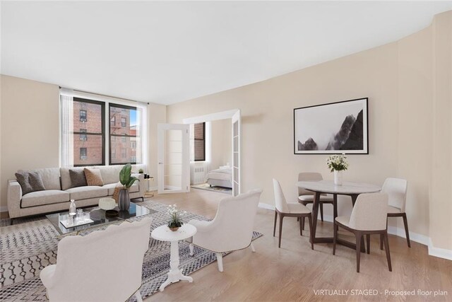 living room with floor to ceiling windows and light hardwood / wood-style floors