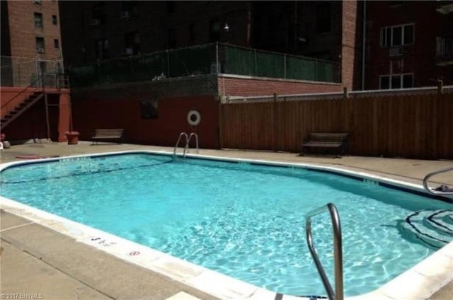 community pool featuring fence and a patio