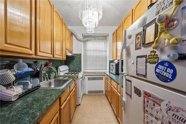 kitchen with sink, light tile patterned floors, radiator, a notable chandelier, and white appliances