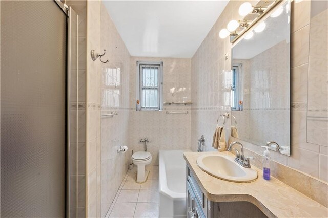 bathroom with a shower with door, tile walls, tile patterned flooring, vanity, and toilet