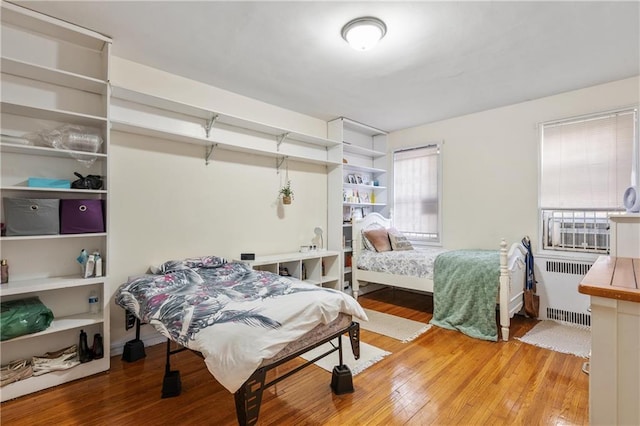 bedroom featuring hardwood / wood-style flooring and radiator