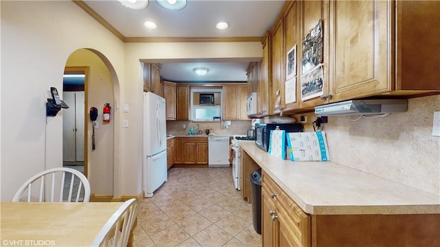 kitchen featuring light tile patterned floors, white appliances, crown molding, and backsplash