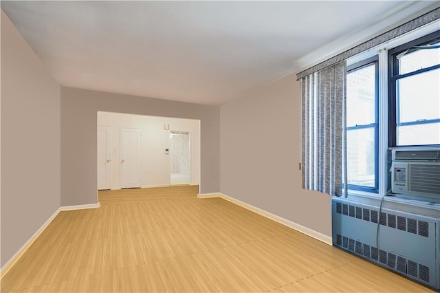 empty room featuring radiator heating unit and baseboards